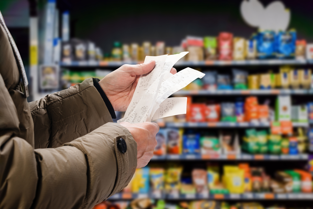 A photo of a shopper holding a receipt to denote October supermarket offers