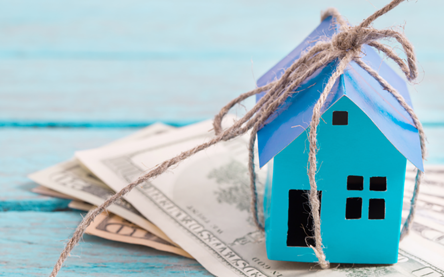 an image of a tied-up model house on a stack of money to denote a story about equity release
