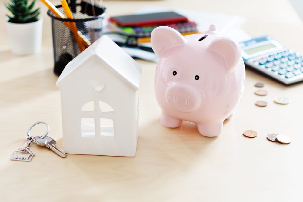 a piggy bank next to a toy house to denote savings rates falling below 5%: Secure an inflation-beating deal now
