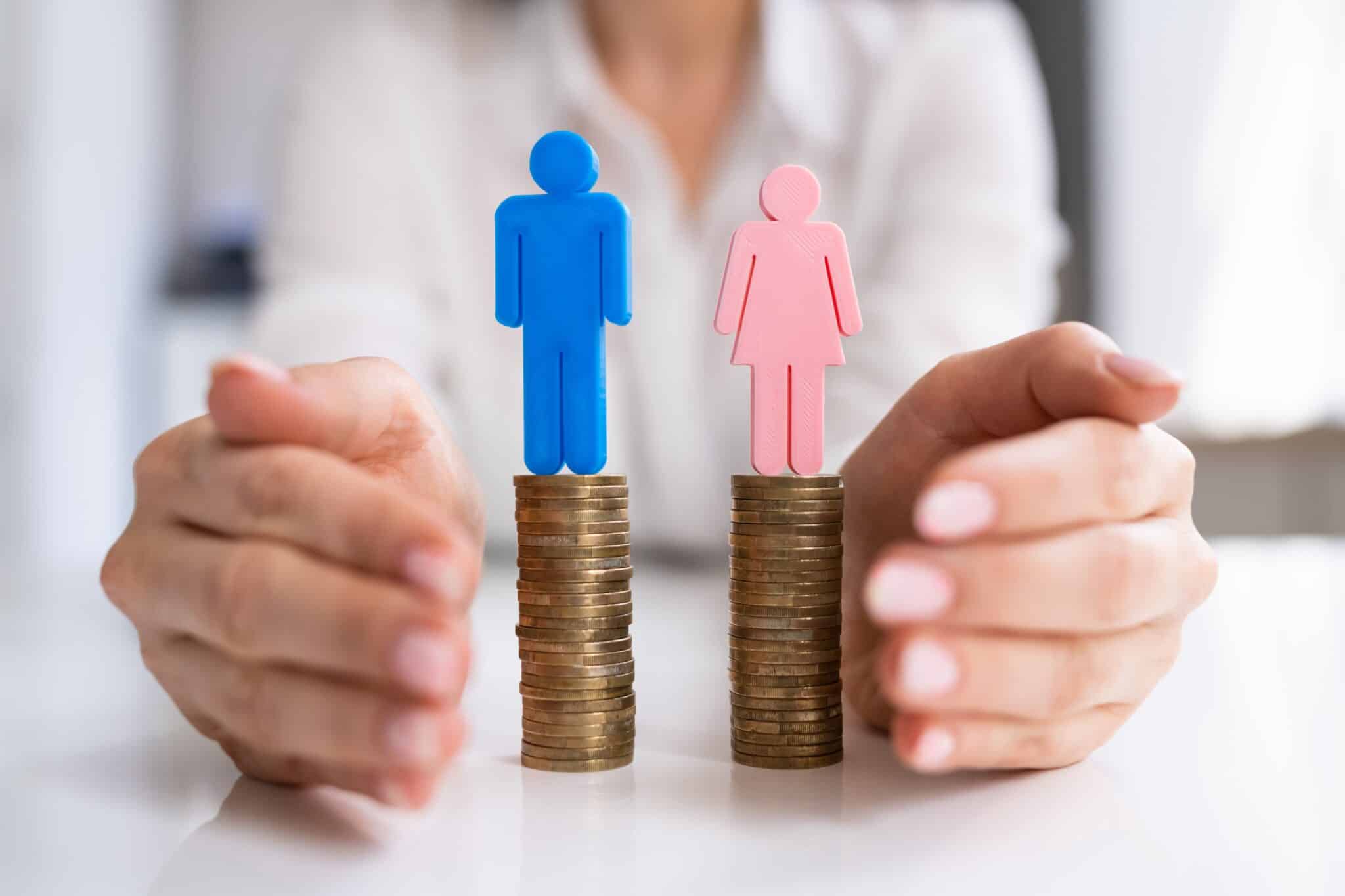 an image of a male sign and female sign on top of a stack of coins to denote a blog on the gender wealth gap