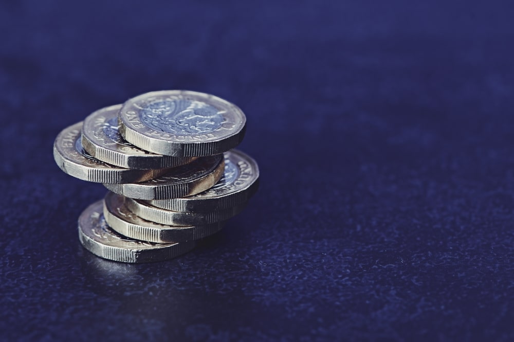 Stack of pound coins on top of a navy surface to denote the uk economy 0.1% growth