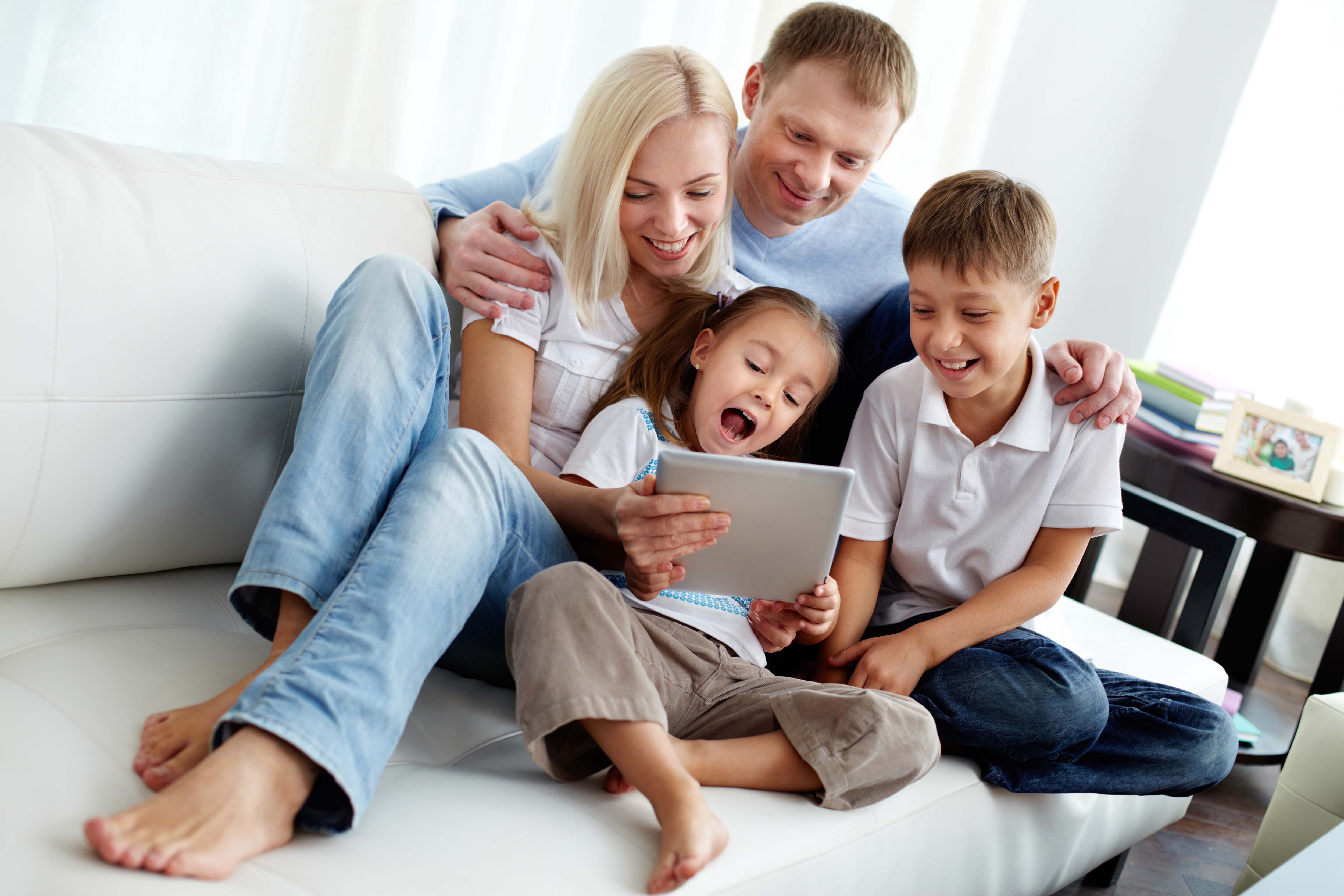 Родители сидят в телефонах. Счастливая семья на диване. Родители и дети. Ребенок в семье. Семья с ноутбуком.